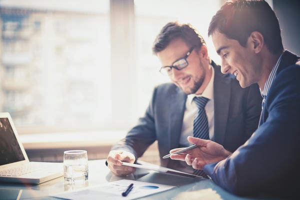 Vermittlungsgutschein beantragen Zwei Männer sitzen zusammen und besprechen die Arbeitsvermittlung