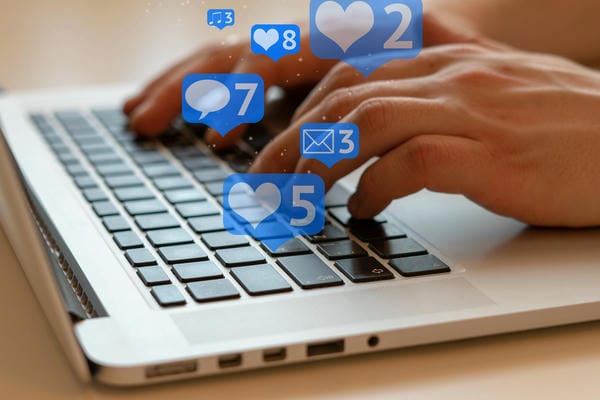 Online Vermarktung eines Unternehmens zwei Hände tippen etwas auf einem Laptop ein. (social Media)