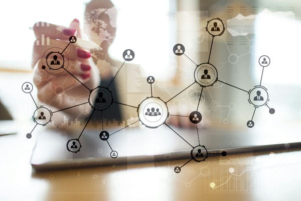 arbeitsmarkt-definition Eine Frau erstellt ein Netzwerk aus Menschen-Symbolen, um deren Verbindungen darzustellen.