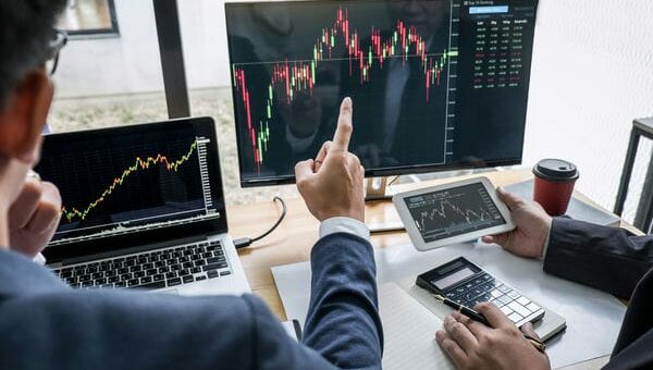 trader gucken sich am laptop einen chart an