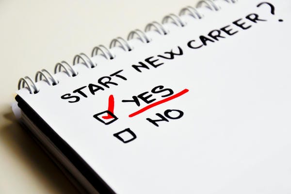 bewerbung-quereinstieg Ein Spiralblock mit der handschriftlichen Frage „START NEW CAREER?“ und einem rot angekreuzten „YES“ als Symbol für einen erfolgreichen Quereinstieg.