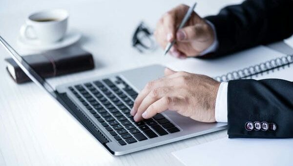 mann im anzug sitzt am laptop