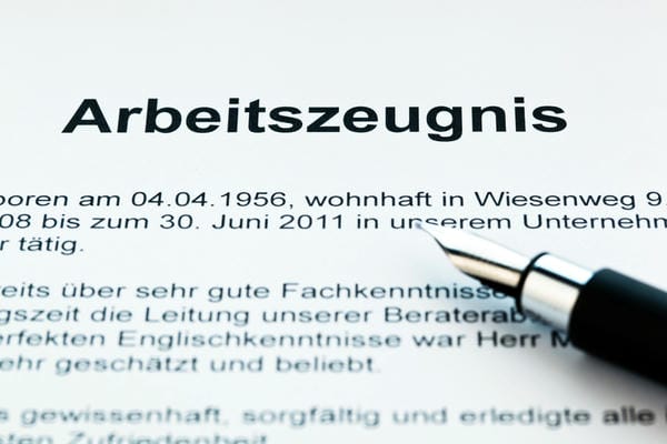 karriere-arbeitszeugnis Ein deutsches Arbeitszeugnis liegt auf einem Tisch, während ein hochwertiger Füllfederhalter auf dem Dokument ruht.
