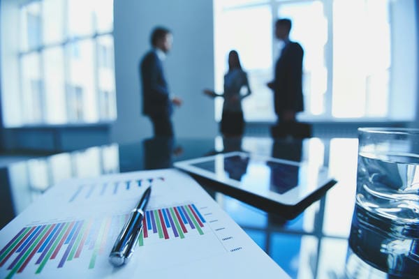 Drei Mitarbeiter stehen im Büro ihrer Unternehmergesellschaft und unterhalten sich.