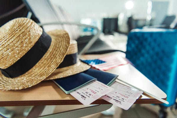 urlaub-bezahlte-freiheit Reiseausrüstung auf einem Tisch mit Sommerhut, Flugtickets und Koffer