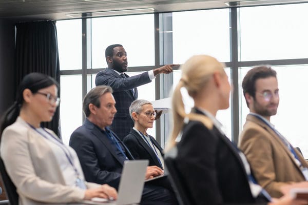 weiterbildung-inhouse-schulungen Mitarbeiter sitzen zusammen einem Raum für Inhouse-Schulungen
