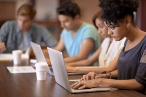 Kollegen sitzen zusammen im Büro menschem arbeiten am laptop